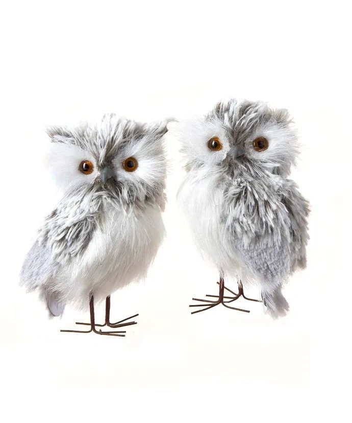 two stuffed owls sitting next to each other on top of a white surface with brown eyes