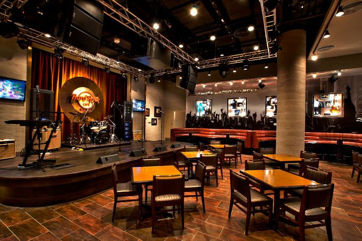 an empty restaurant with tables and chairs in front of a large screen tv on the wall