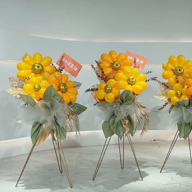 three vases filled with yellow flowers and green leaves