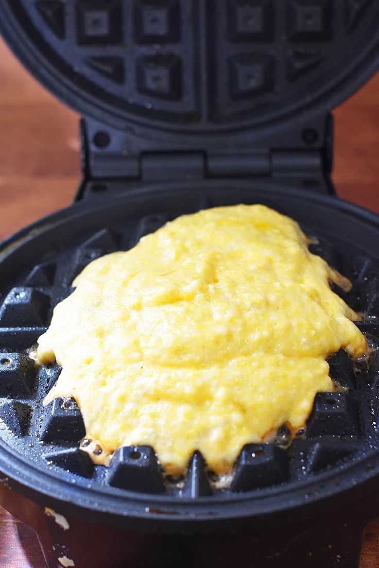 a waffle topped with cheese sitting on top of a wooden table