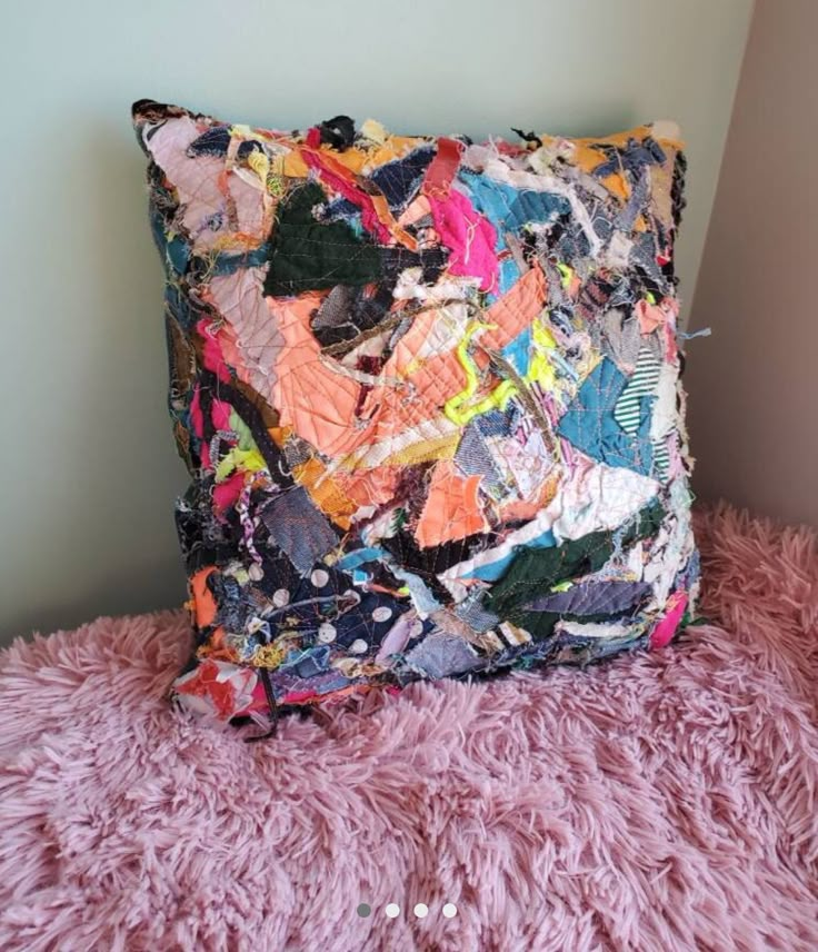 a pillow made out of fabric on a pink blanket