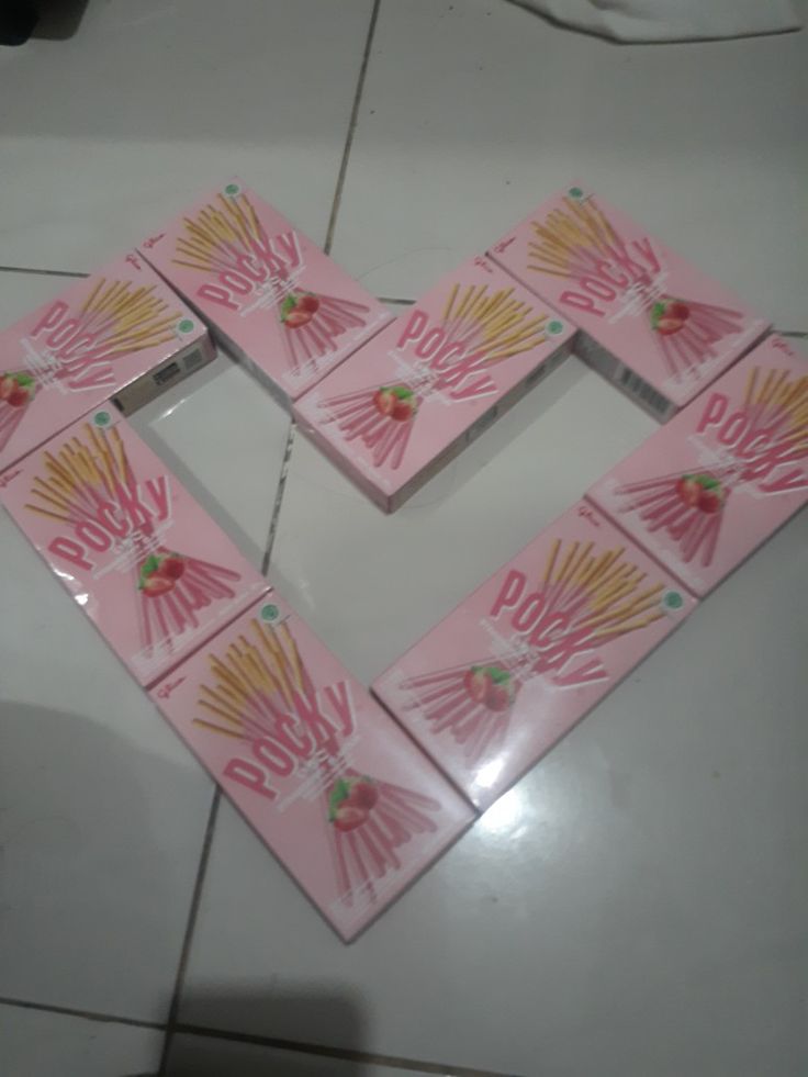 four pieces of pink and gold paper with hand prints in the shape of a heart