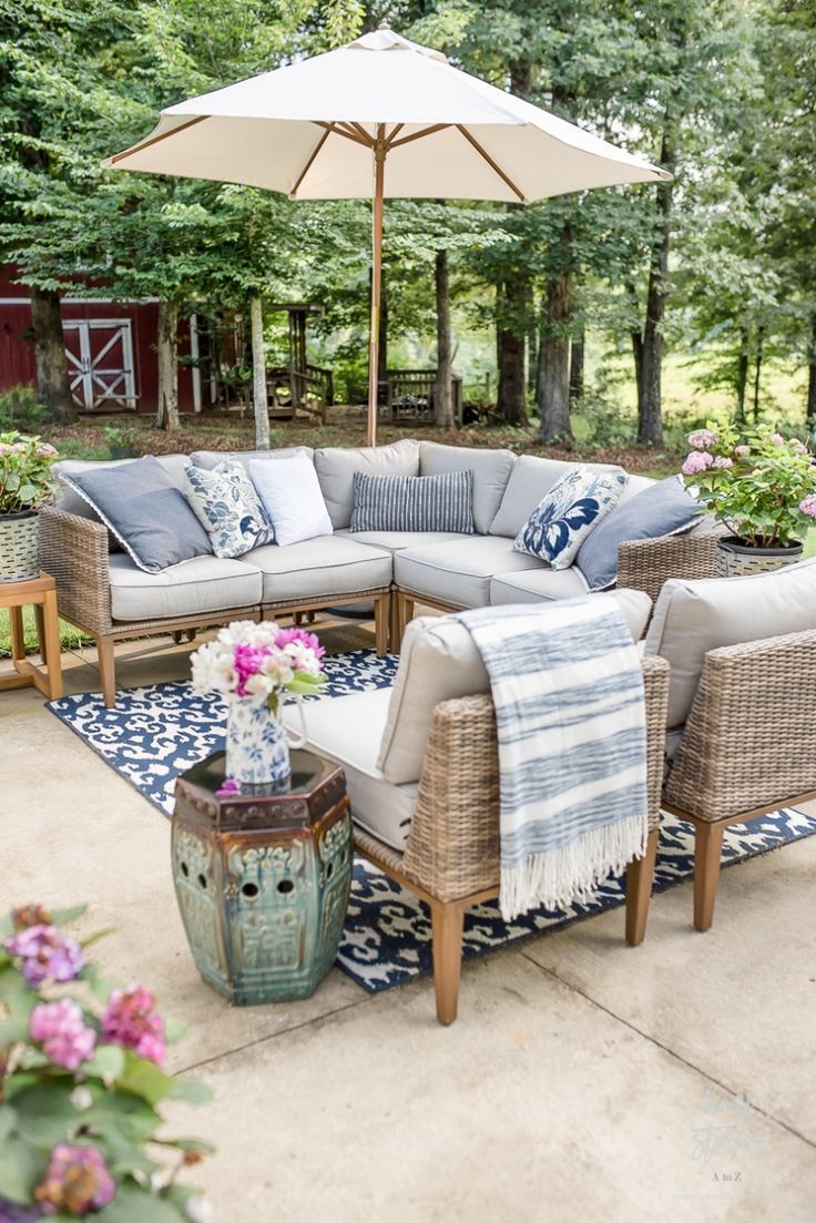 an outdoor living area with furniture and umbrella