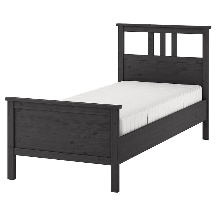 the bed frame is made from wood and has white sheets