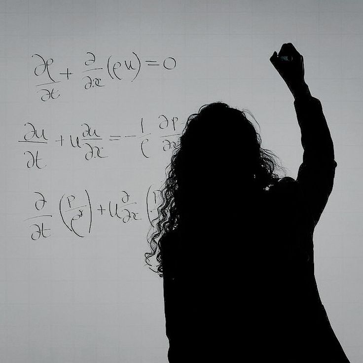 a woman raising her hand in front of a whiteboard