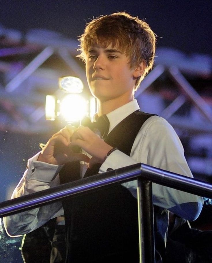 a young man standing at a podium holding a light