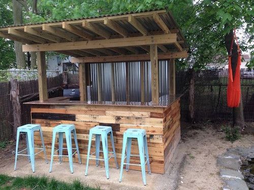 an outdoor bar made out of pallets with stools