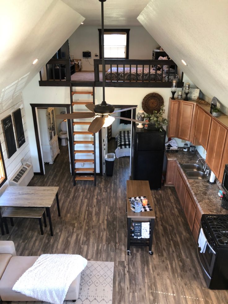 an overhead view of a kitchen and living room in a tiny house with wood flooring