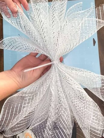 someone is working on something that looks like a flower with white mesh attached to it