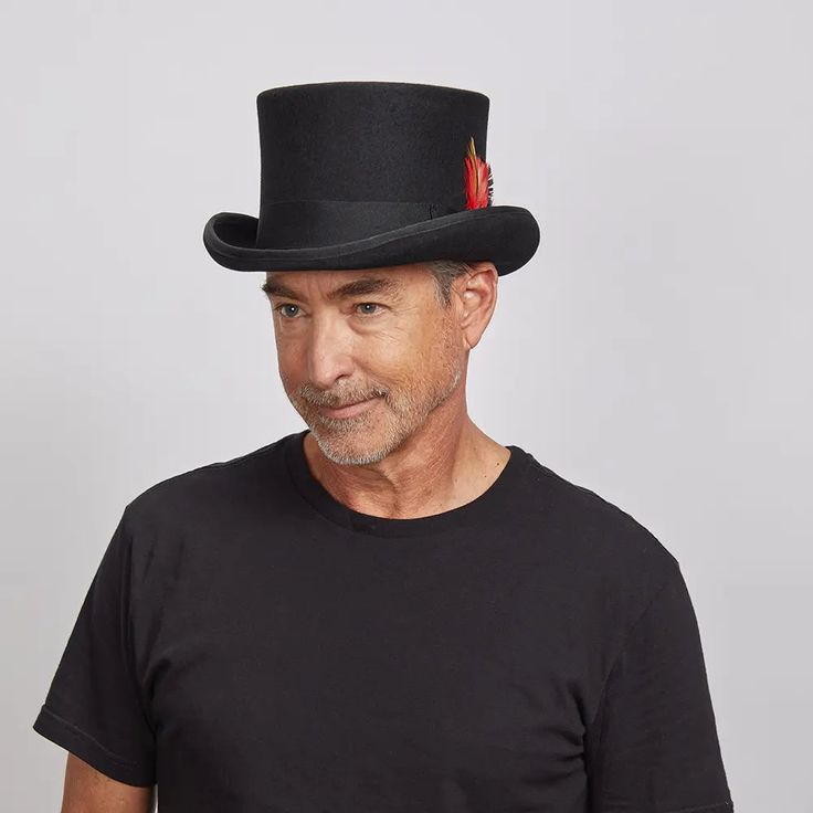 Majestic | Mens Wool Top Hat with Carriage Hat Band is a timeless symbol of sophistication. Made from lightweight wool felt, this top hat boasts a sleek 5-inch crown and a bound edge 2-inch brim. Its ribbon feather band adds an elegant flourish, while the AHM Velcro sweatband ensures a secure and comfortable fit. Perfect for formal occasions or statement wear. Imported to deliver enduring style. Material: Lightweight Wool Felt Shape: Top Hat Trim: Grosgrain Ribbon Band with Red Dotted Feathers B Circus Top Hat, True Gentleman, Dapper Gentleman, Top Hat, Hat Band, Timeless Classic, Hat Fashion, Gentleman, Wool