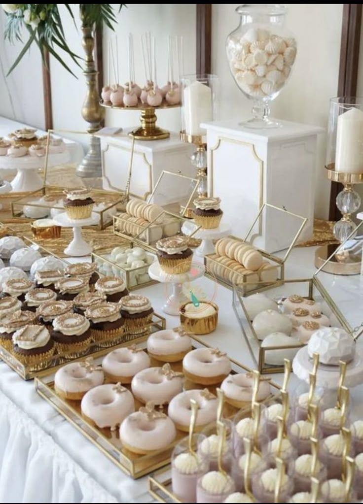 a table topped with lots of donuts and cupcakes