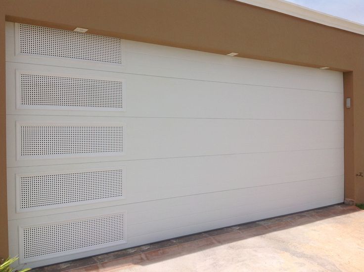 a white garage door in front of a tan building