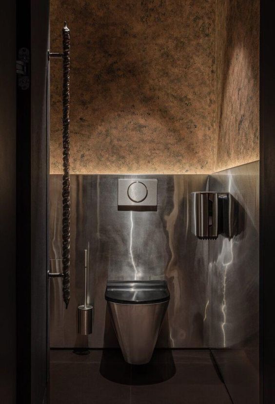 a bathroom with a metallic toilet in the middle of it's walls and lighting on either side