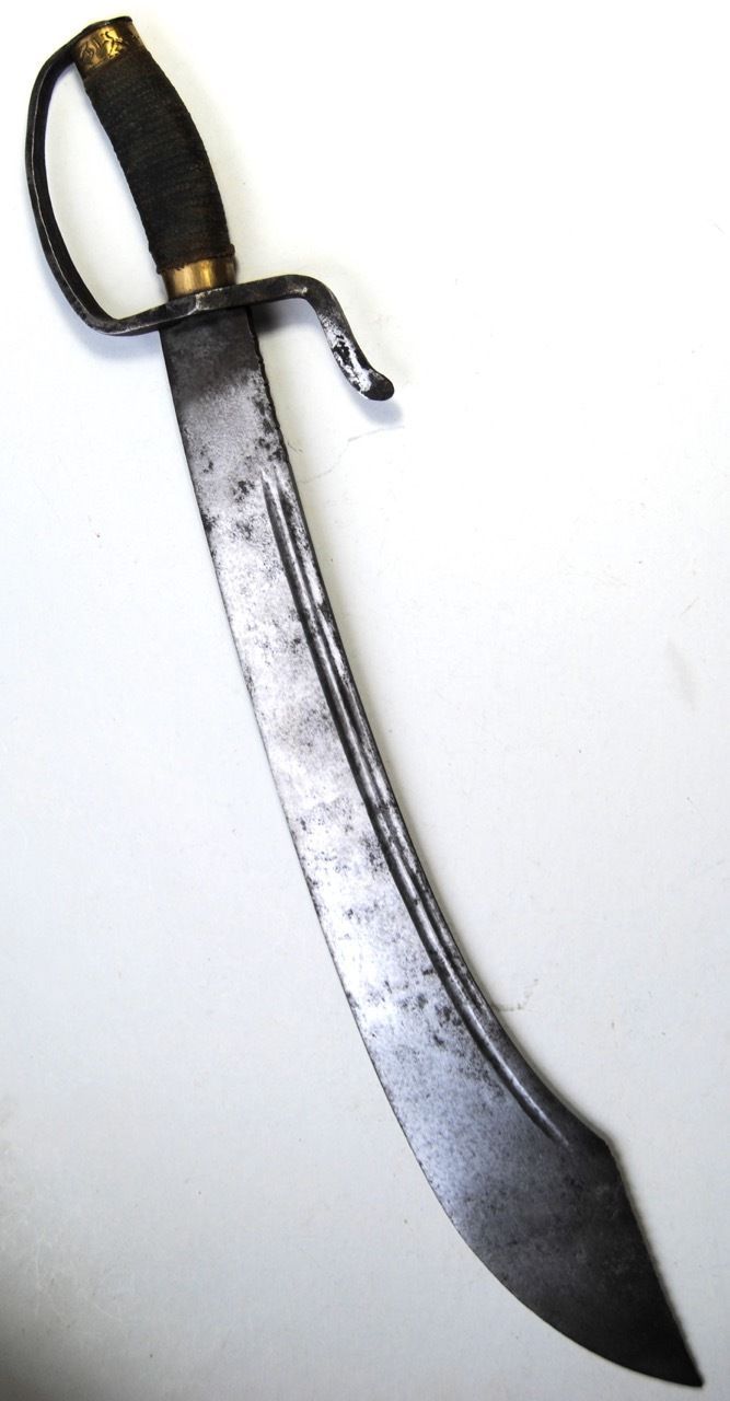 a knife that is sitting on top of a white surface with a black handle and gold accents