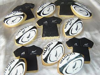 cookies decorated with black and white shirts on top of a sheet of foiled paper