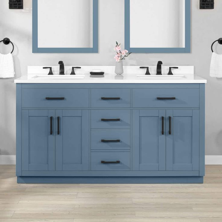 a bathroom vanity with two sinks and mirrors