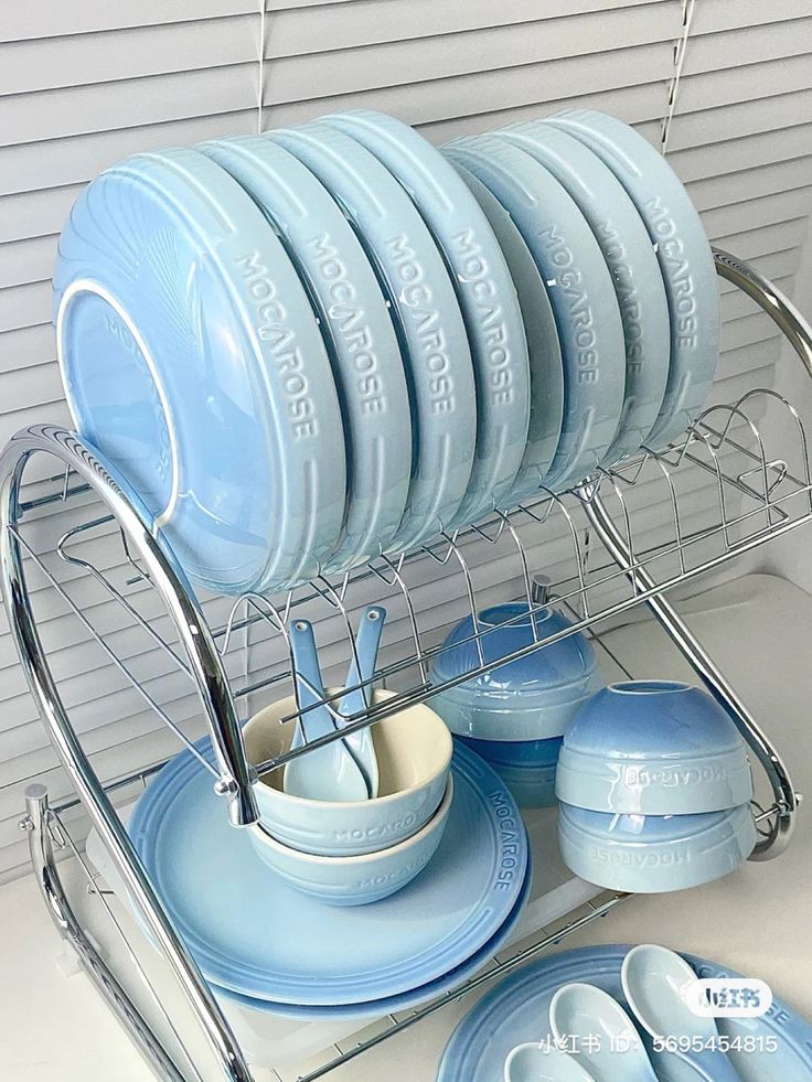 blue dishes are stacked on a metal rack