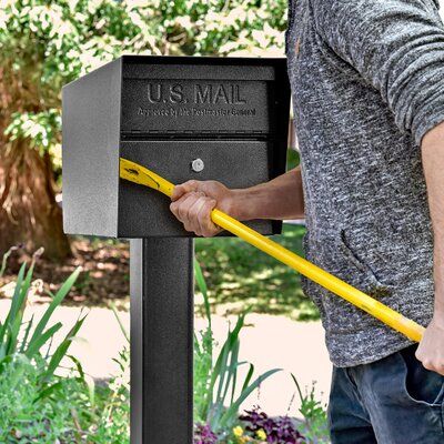 a man is opening the mailbox with a large yellow handled tool in his hand