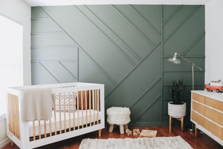 a baby's room with a crib, dresser and bed in the corner