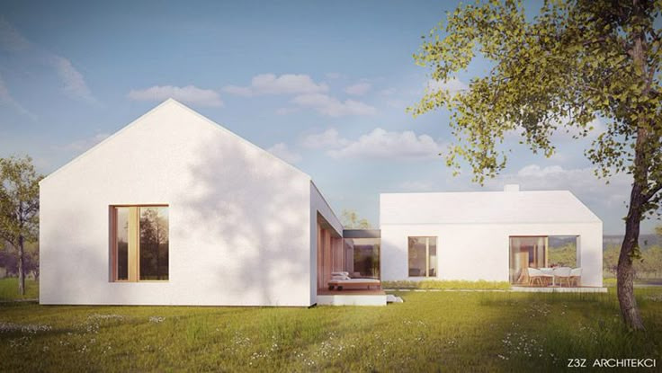 two small white houses sitting on top of a lush green field