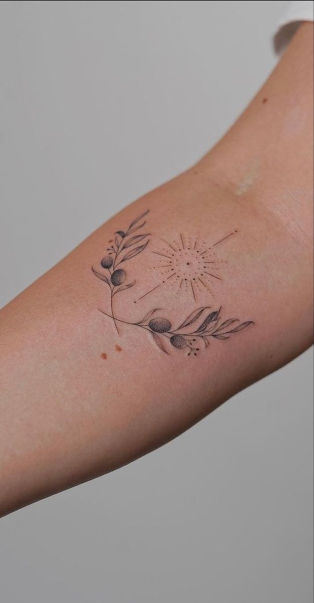 a woman's arm with a flower tattoo on the left side of her arm