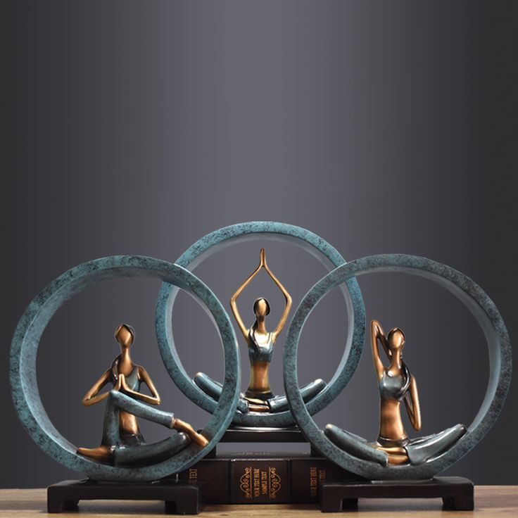 three bronze figurines sitting on top of each other in front of a black background