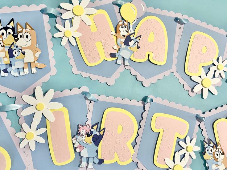 a birthday banner with cartoon animals and flowers on it's sides, hanging from the wall