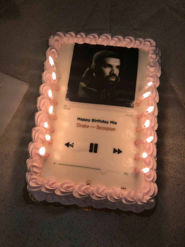 a birthday cake with an image of a man on the side and candles around it