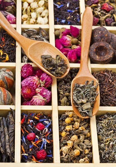 several wooden spoons filled with different types of tea