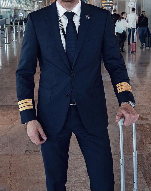 a man in a suit and tie is holding a luggage bag at an airport terminal