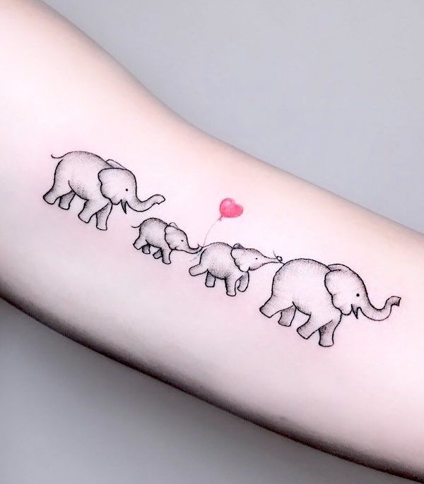 an elephant family tattoo on the arm with a red balloon in the shape of a heart