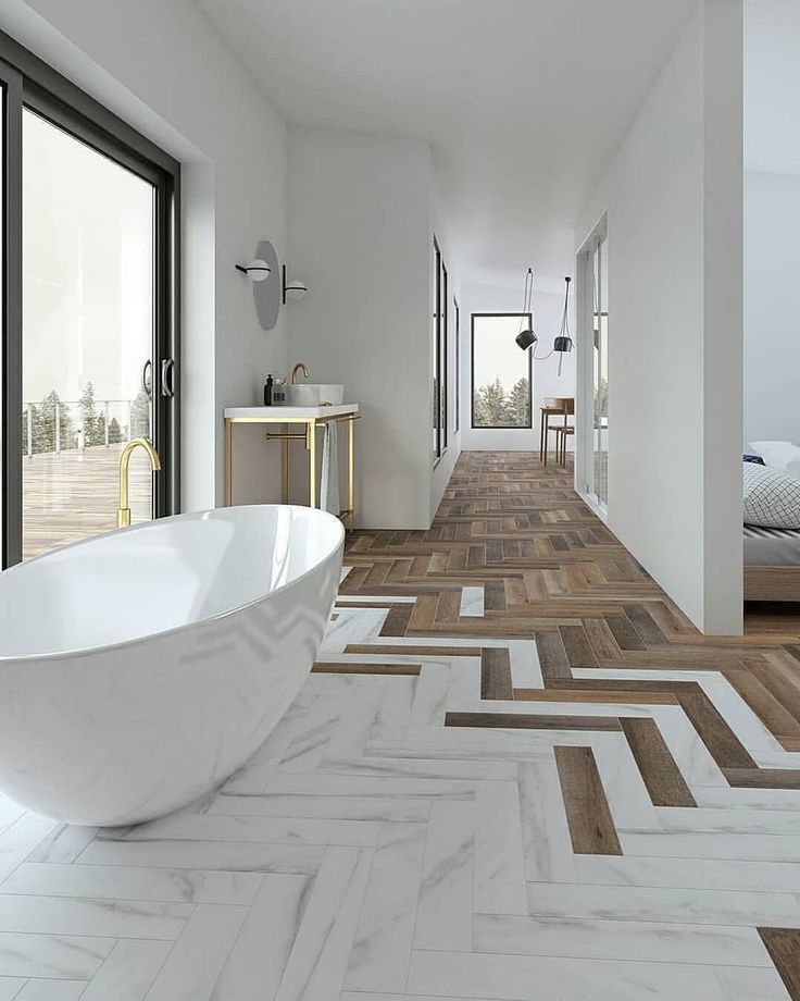 an image of a white bathroom with wood flooring and large tub in the middle