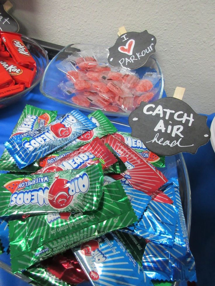 some candy bags are sitting on a blue tablecloth and there is a sign that says catch air