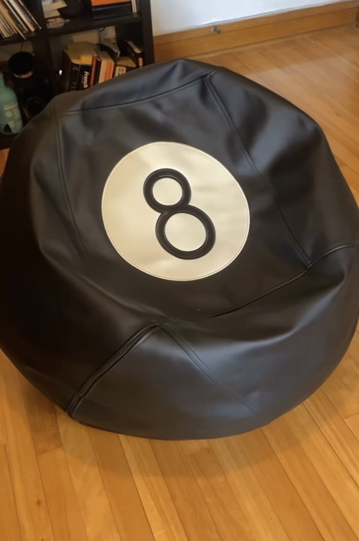 a black bean bag chair sitting on top of a hard wood floor