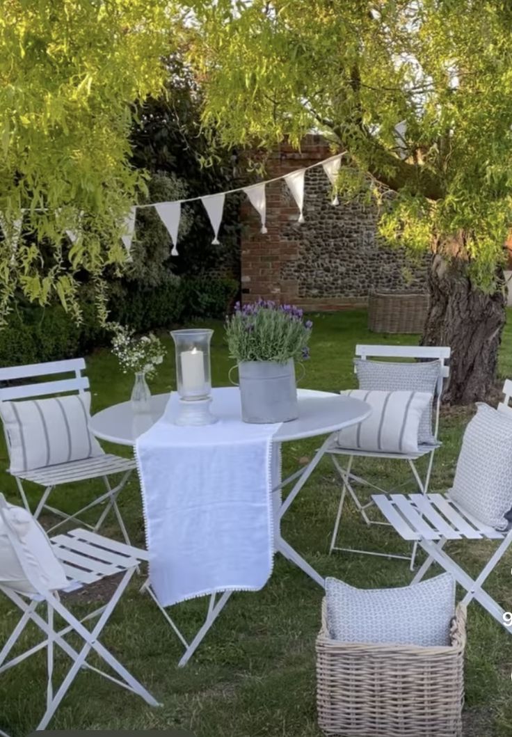 a white table and chairs sitting in the grass