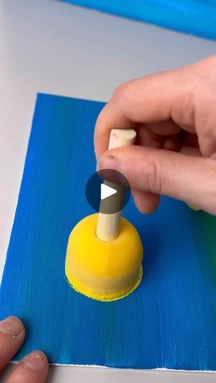 someone is making something out of construction paper with a small object in front of them