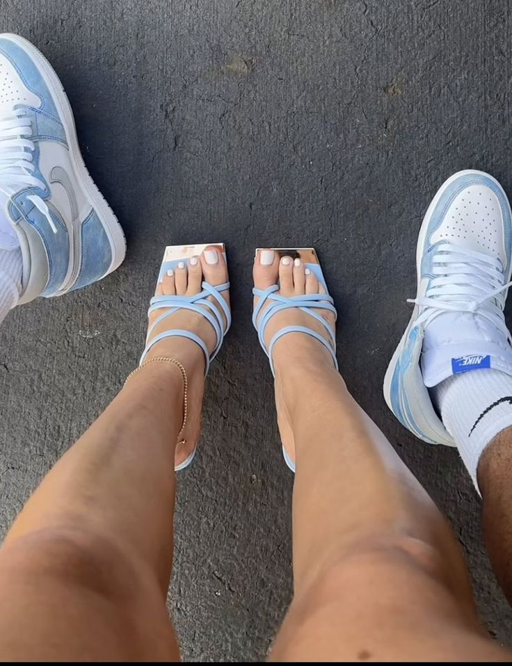 two people standing next to each other wearing blue and white shoes with their feet crossed