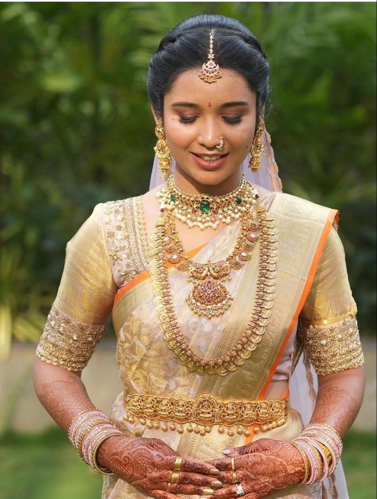 a woman in a bridal outfit holding her hands together