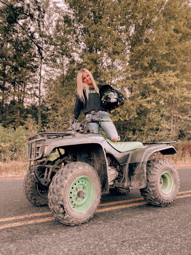 a woman riding on the back of an atv