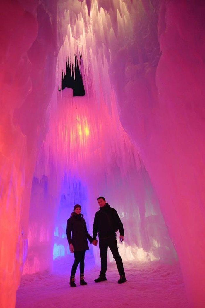 two people standing in an ice cave holding hands