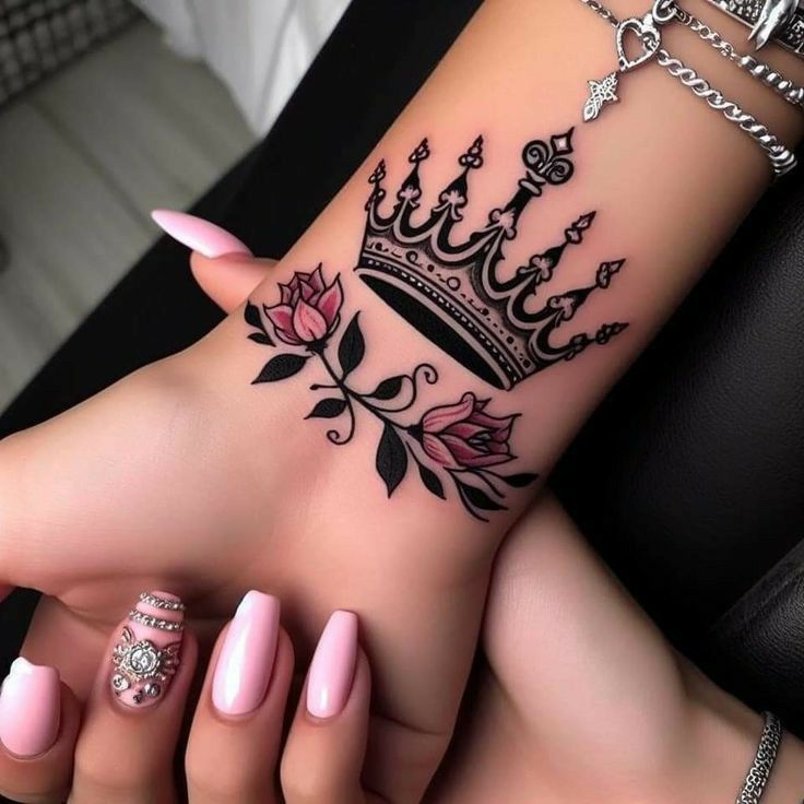 a woman's foot with a crown tattoo on it and pink nail polishes