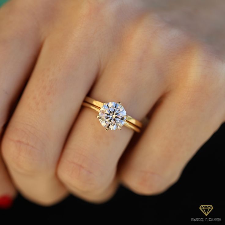 a woman's hand with a diamond ring on her finger, showing the center stone