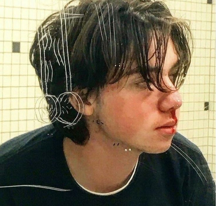 a woman with black hair and piercings in a bathroom