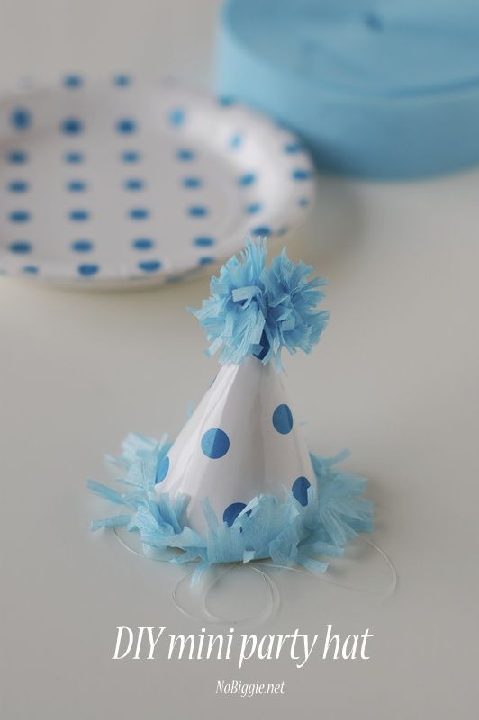 a blue and white party hat sitting on top of a table next to other plates