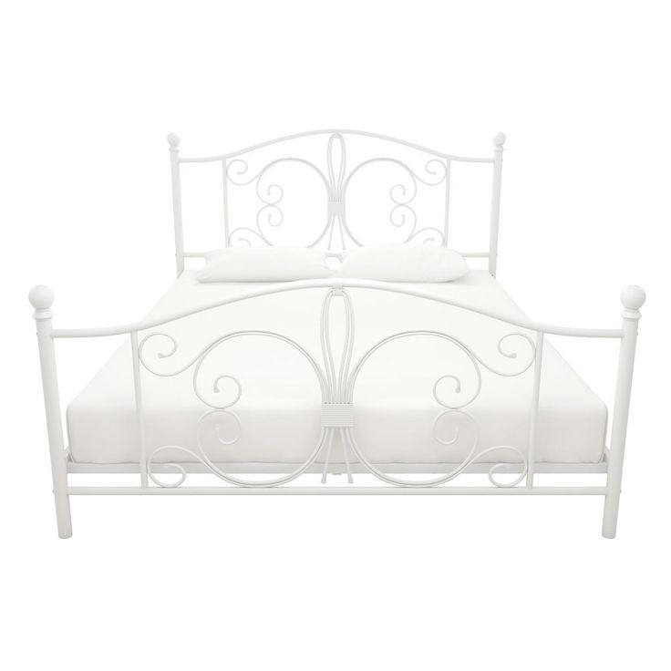 a white metal bed frame with two pillows