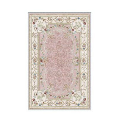 a pink and white rug with an ornate border