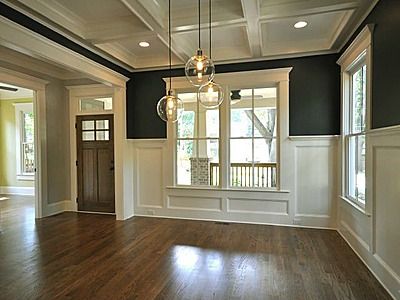 an empty room with hard wood floors and black walls