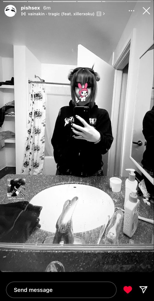 a person wearing a cat mask standing in front of a bathroom mirror with her hand on her face