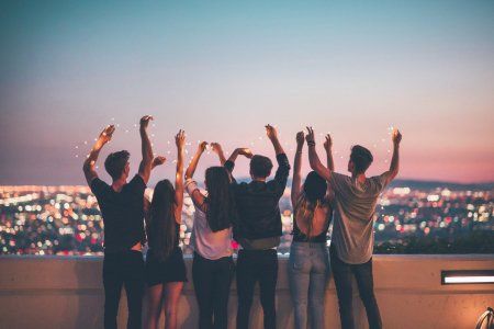 a group of people standing on top of a roof with their hands in the air