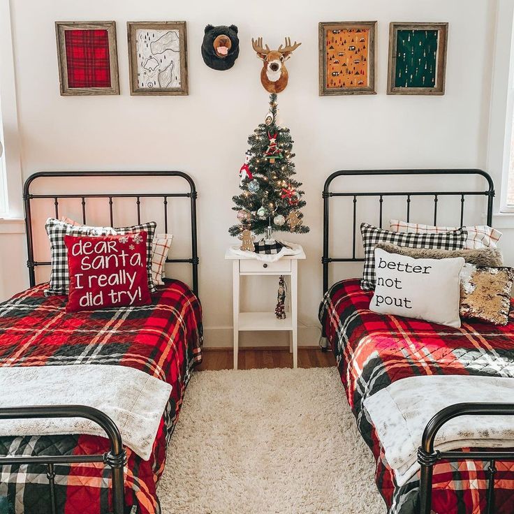 two twin beds in a bedroom decorated for christmas with plaid bedding and decorations on the wall